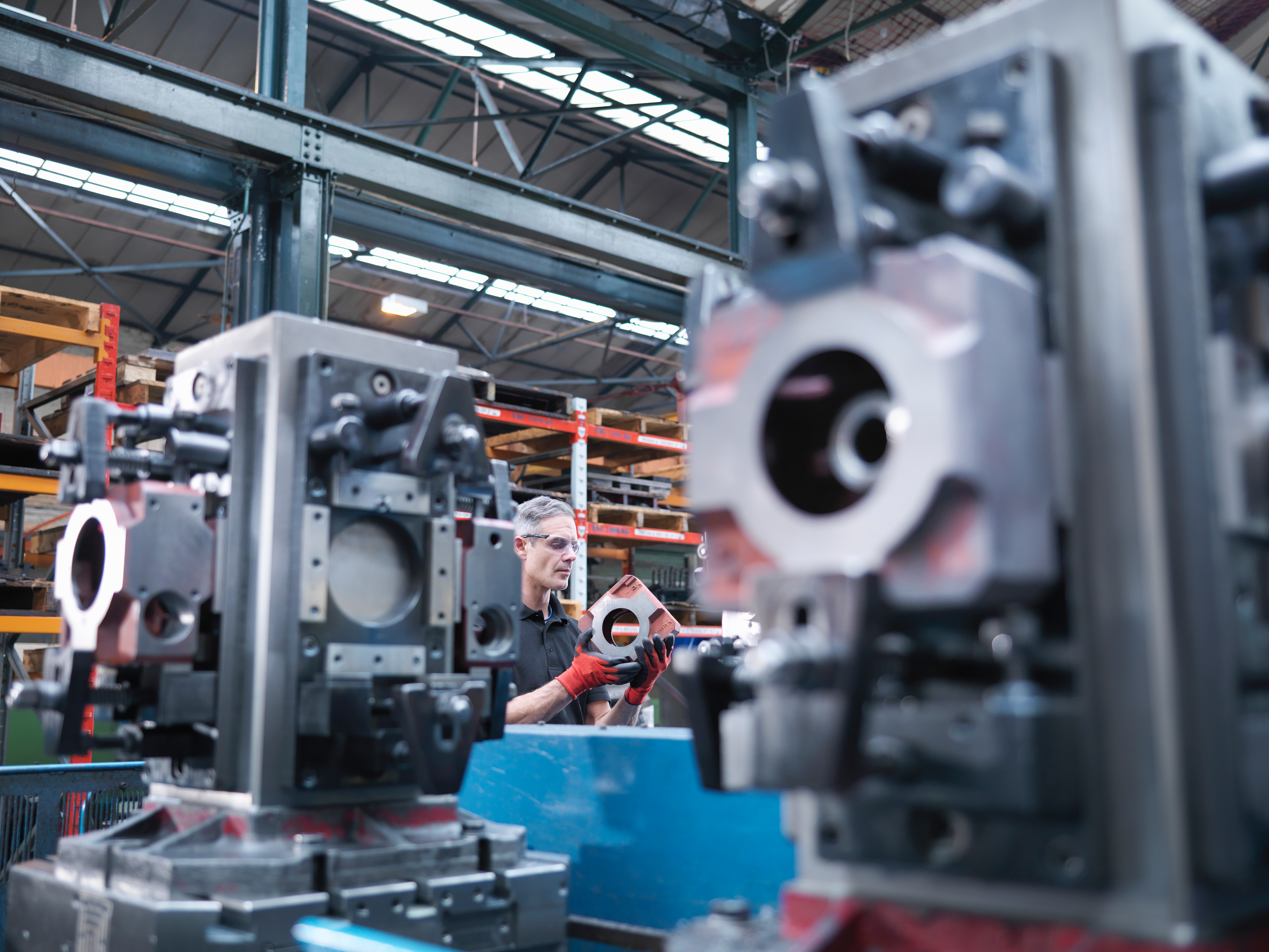 Engineer inspecting parts on an automatic lathe